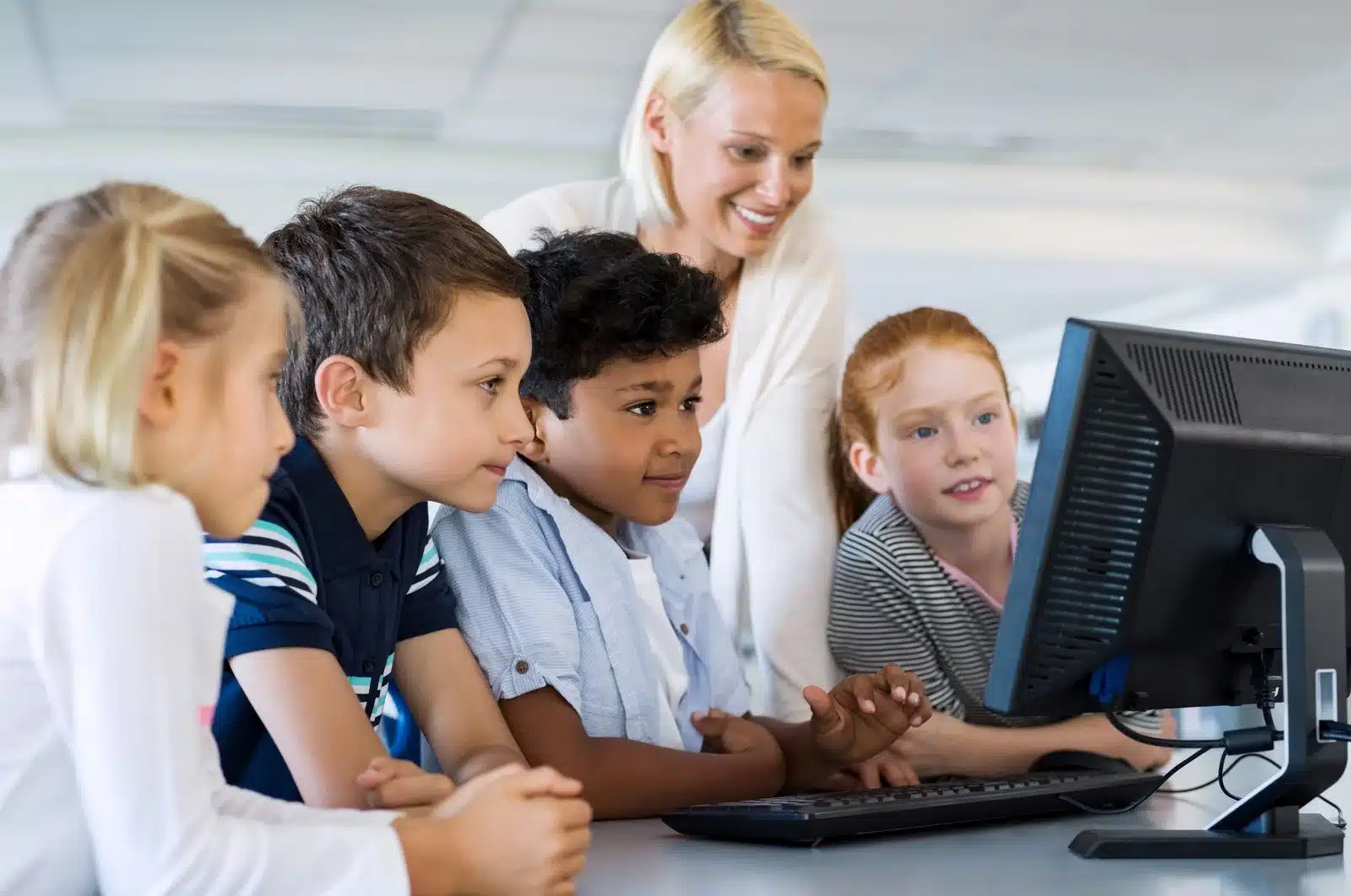 Enfants et enseignante utilisant un ordinateur.