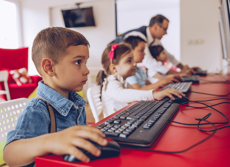 Enfants apprenant à utiliser des ordinateurs en classe.